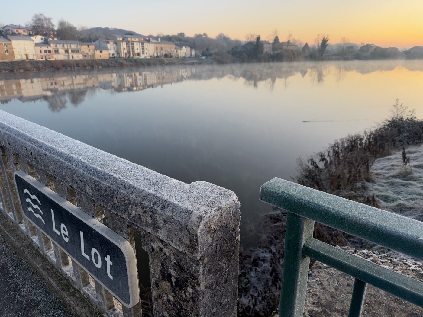 Les toits vus du coteau, la pente douce qui mène à la rivière.